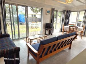 a living room with a couch and a table at Pauanui Guesthouse in Pauanui