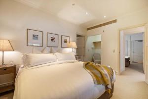 ein Schlafzimmer mit einem großen weißen Bett in einem Zimmer in der Unterkunft Craigroy 1 Lakeshore apartment with conservatory in Queenstown