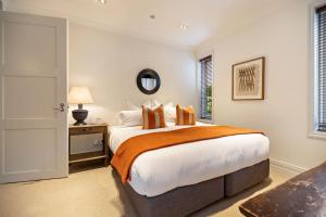 a bedroom with a large bed and a window at Craigroy 2 Lakeshore apartment with conservatory in Queenstown