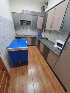 a kitchen with a blue counter in a room at Kashees Lodges in Islamabad +28 photos