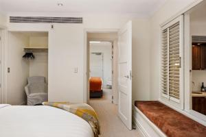 a bedroom with a bed with a bench in it at Ben Lomond 1 Top Floor Lakeshore Apartment in Queenstown