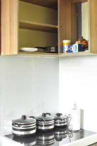 un grupo de ollas y sartenes sobre una estufa en una cocina en Savannah Suites Gilgil, en Gilgil