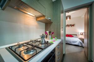 a kitchen with a stove top oven next to a bed at Casetta Venere in Castellammare del Golfo