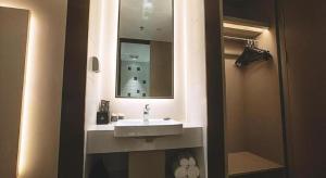 a bathroom with a sink and a mirror at Magnotel Hotel Wuhan Meiyuan Xiaoqu Metro Station Dream Times in Wuhan