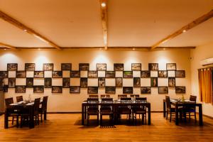 a dining room with tables and chairs and pictures on the wall at Greetoe Camp Panna in Khajurāho +30 photos