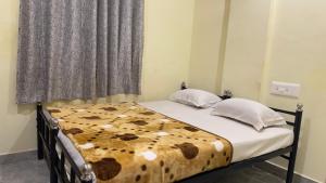 una camera con un letto con una coperta marrone e bianca di Mysuru-hotel a Mysore