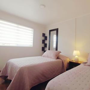 a bedroom with two beds and a window at Hospedaje Valle Volcanes in Puerto Montt