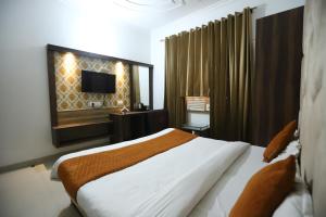 Un dormitorio con una cama grande y un televisor. en INN Malhotra, en Amritsar