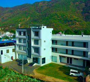 プシュカルにあるThe Triple Seven - A Luxury Boutique hotel best Mountain view in Pushkarの白い建物とその前に駐車されたバン