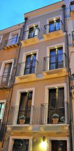 a tall building with windows and potted plants on it at Oisife Apartments in Cagliari