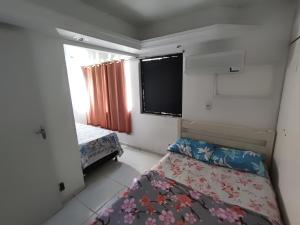 a small bedroom with a bed and a window at Apartamento dúplex em frente ao mar de Pajuçara in Maceió +22 photos