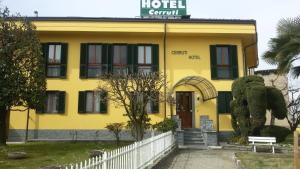 un bâtiment jaune avec une clôture blanche devant lui dans l'établissement Cerruti Hotel, à Verceil