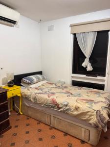 a bedroom with a bed and a window at Single room with shared bathroom 2 in Springvale South