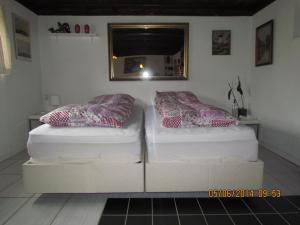 キューゲにあるケーエ ベッド ＆ キッチンの鏡付きの客室内のツインベッド2台