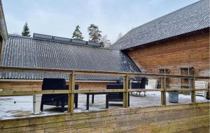 a wooden deck with chairs and a building at Awesome Apartment In Mullsjö With Wifi in Mullsjö