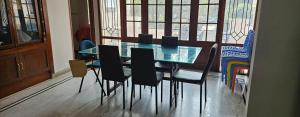 a dining room with a glass table and chairs at Prashanth kuteer in Hyderabad +7 photos