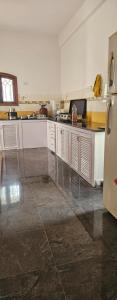 a kitchen with white cabinets and a refrigerator at Prashanth kuteer in Hyderabad