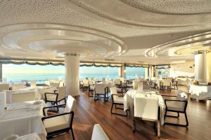 a restaurant with white tables and chairs and a ceiling at Vincci Selección Aleysa in Benalmádena