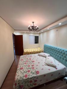 a bedroom with a bed and a chandelier at Suíte por do sol 3 privada casa compartilhada in Xangri-lá