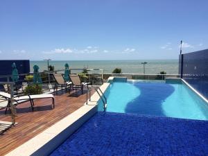 una piscina en la parte superior de un edificio con el océano en Apartamento Tambau a Beira Mar, en João Pessoa