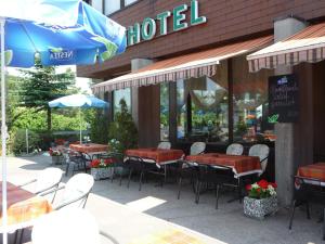 a restaurant with tables and chairs in front of a building at Hotel Panorama Windegg in Langnau am Albis