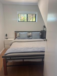 a bed in a bedroom with a window above it at Sandbar views in Smiths Lake