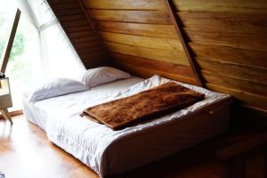 DiyengにあるSavana Cabin by Fifa Grupの毛布が付いた部屋のベッド1台