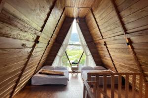 DiyengにあるSavana Cabin by Fifa Grupのベッド2台と窓が備わる屋根裏部屋です。