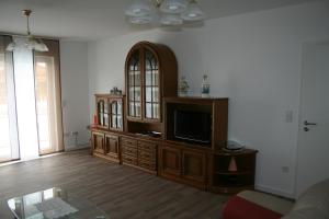 una sala de estar con un centro de entretenimiento con TV de pantalla plana en Ferienwohnung zur Stadtmauer, en Bad Bergzabern