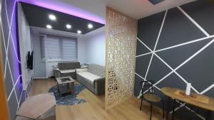 un salon avec un canapé et une table dans l'établissement Golden Luxury Neom apartman, Stup, Sarajevo, à Sarajevo