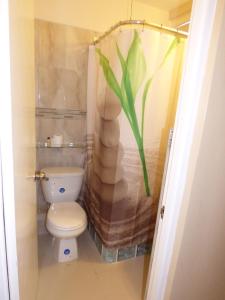 a bathroom with a toilet and a bamboo shower curtain at Beach Studio 30 in Ocho Rios