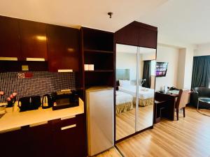 una camera d'albergo con letto e cucina con scrivania di Royal Crown Scsp KK CBD near Imago a Kota Kinabalu