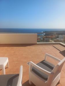 a balcony with a table and chairs and the ocean at VILLA CHRIS Ocean View in La Jaca
