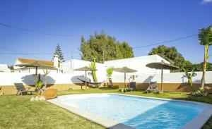 een zwembad in een tuin met stoelen en parasols bij Casa ZAHOMAR con piscina exterior in Zahora