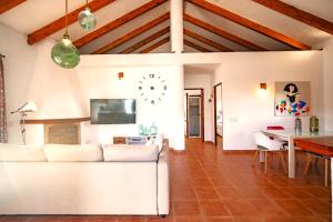een woonkamer met een witte bank en een klok aan de muur bij Casa ZAHOMAR con piscina exterior in Zahora