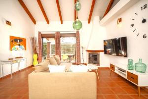 een woonkamer met een bank en een klok aan de muur bij Casa ZAHOMAR con piscina exterior in Zahora