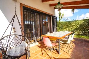 een veranda met een schommel en een tafel en stoelen bij Casa ZAHOMAR con piscina exterior in Zahora