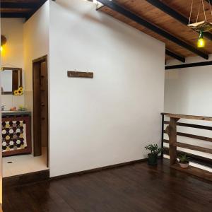 a room with a white wall and a wooden floor at Posada María E in Mucuchíes +10 photos