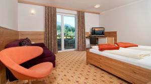 una stanza d'albergo con un letto e una sedia di Erlebnis-Hotel-Appartements a Latschach ober dem Faakersee