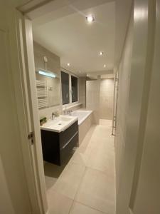 a bathroom with a sink and a tub and a mirror at NEW Appartment Zandvoort! in Zandvoort +33 photos