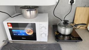 a microwave oven with a pot on top of it at 22 Skyview in Bukit Mertajam
