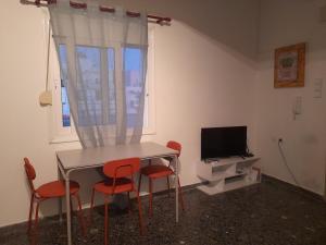 una camera con tavolo, sedie e televisore di Evropis penthouse a Heraklion