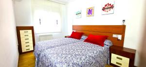 een slaapkamer met een bed met 2 rode kussens bij NEXTHOME Beach & Pool in Lloret de Mar