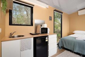 CashmoreにあるBushland Haven by Tiny Awayのシンク付きのキッチンとベッドが備わった部屋