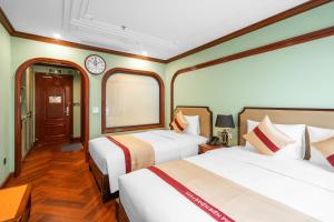 a bedroom with two beds and a clock on the wall at 12 A&B Điện Biên Phủ Hà Nội Hotel in Hanoi +73 photos