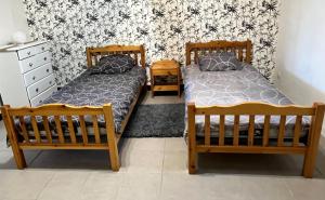 deux lits côte à côte dans une chambre dans l'établissement Joli logement proche du Mont Lozère, à La Vernarède