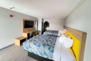 a hotel room with a bed and a television at Days Inn by Wyndham Gonzales in Gonzales