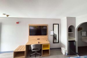 a room with a desk and a television on a wall at Days Inn by Wyndham Gonzales in Gonzales +15 photos