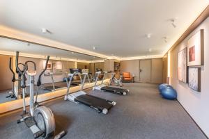 a gym with several treadmills and exercise bikes at Madison Hotel, Qingdao Laoshan Polar Ocean Park in Qingdao