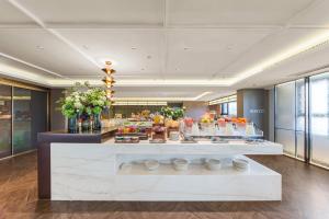a buffet line in a hotel lobby with desserts at Madison Hotel, Qingdao Laoshan Polar Ocean Park in Qingdao